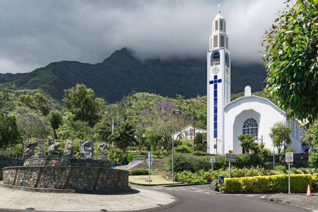 Église blanche au clocher élancé au pied des montagnes de La Réunion